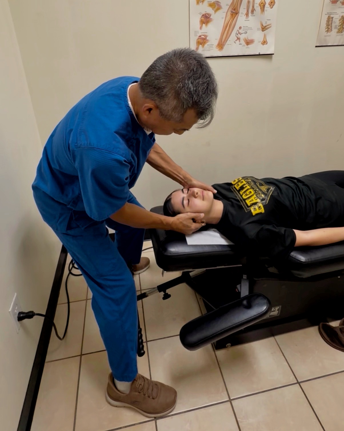 Dr. Bui performing a gentle cervical spine adjustment on a patient's neck